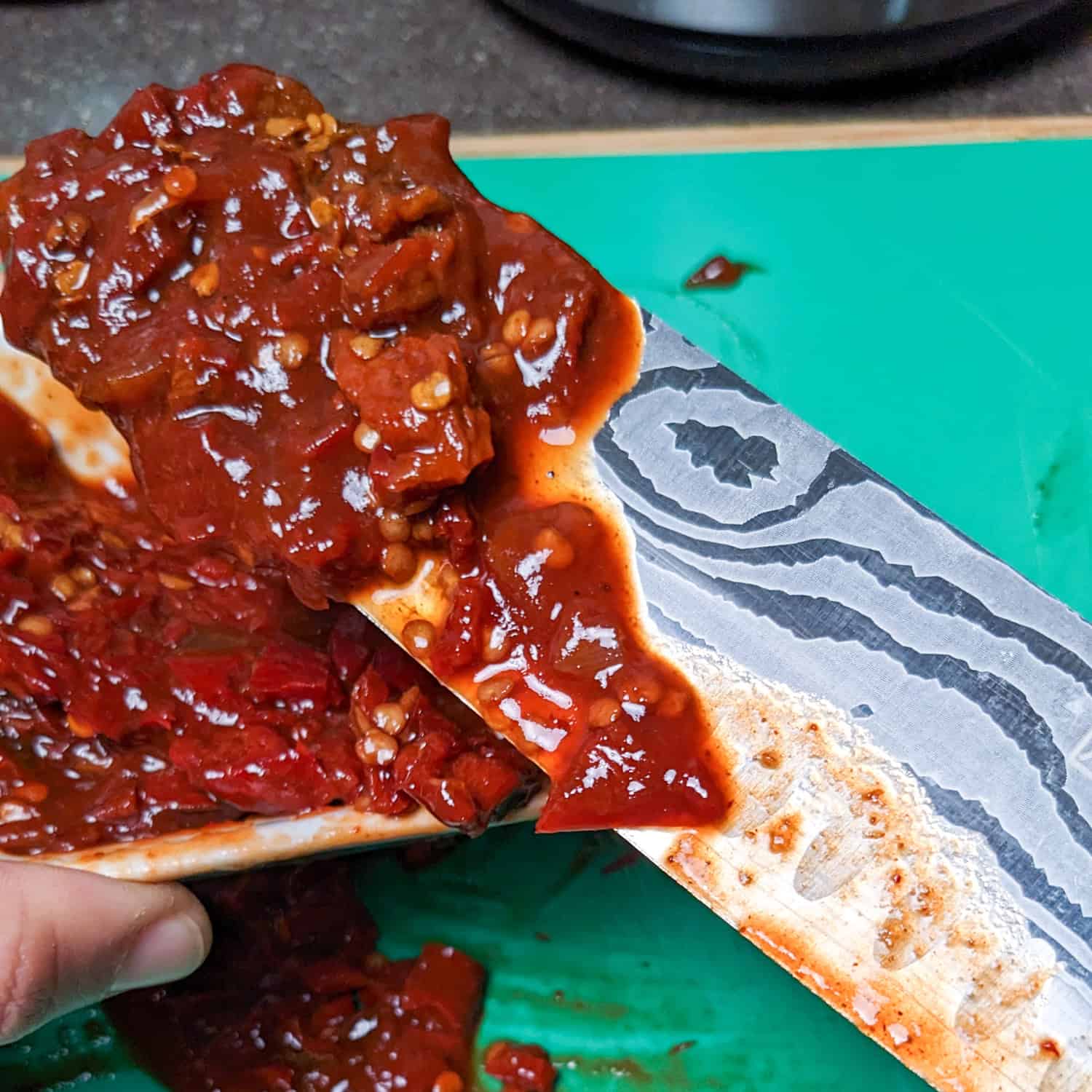 chopped chipotle in adobo on a plastic cutting board.